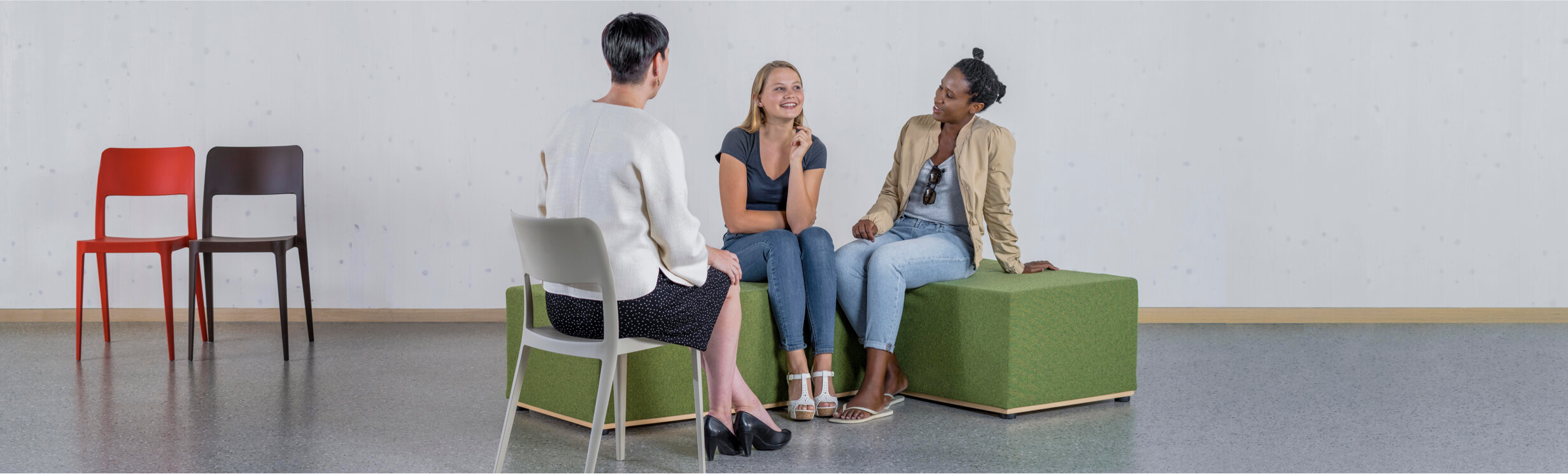 Drei Frauen sitzen beisammen und unterhalten sich